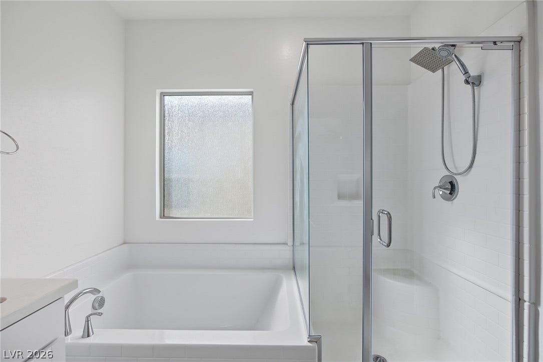 2728 Lindsey Springs Street, Las Vegas, NV 89142 A deep soaking tub sits adjacent to a glass-enclosed walk-in shower under clean, modern finishes.