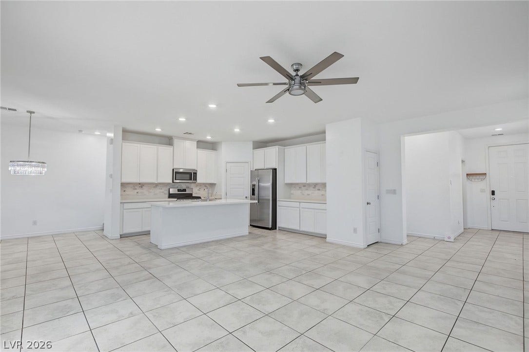 2728 Lindsey Springs Street, Las Vegas, NV 89142 Tiled flooring anchors this open kitchen layout featuring a central island and white cabinetry.