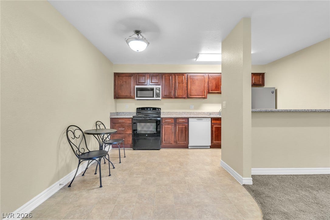 Rich wood cabinetry contrasts beautifully with tiled flooring in this open-concept kitchen.