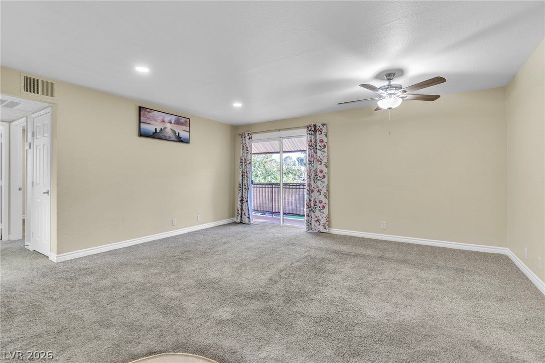 Sliding glass doors open to a private balcony from this spacious carpeted room.