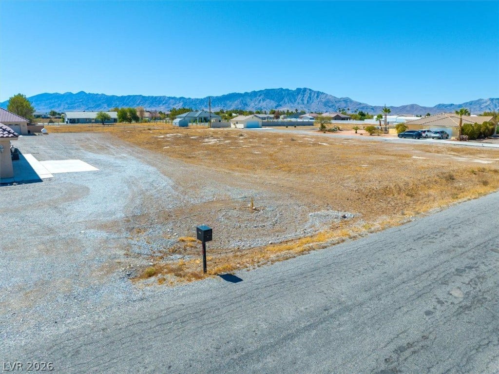 1641 W Huckleberry Street, Pahrump, NV 89048 A spacious vacant lot frame majestic mountain views under a clear blue sky.