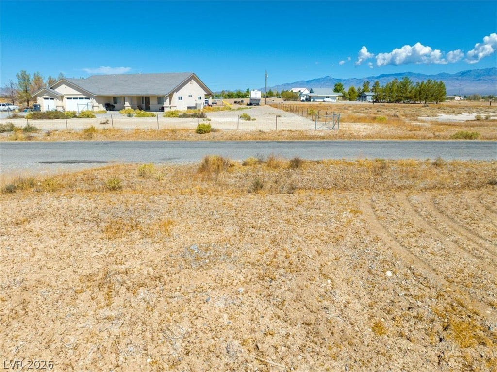 1641 W Huckleberry Street, Pahrump, NV 89048 A spacious desert lot boasts panoramic mountain views under clear blue skies.