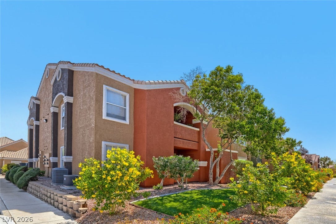 8101 W Flamingo Road, #1074, Las Vegas, NV 89147 Multi-level stucco exterior showcases arched architectural details and tiled roofing under a clear sky.