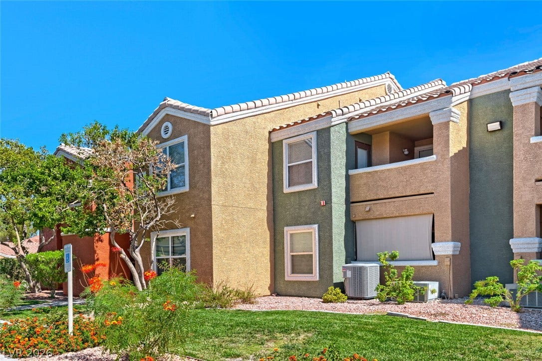 8101 W Flamingo Road, #1074, Las Vegas, NV 89147 Stucco exteriors and tiled rooflines stand out under a clear blue sky.