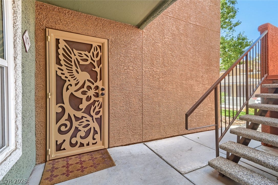 8101 W Flamingo Road, #1074, Las Vegas, NV 89147 An ornate screen storm door leads into the home next to outdoor stairs.