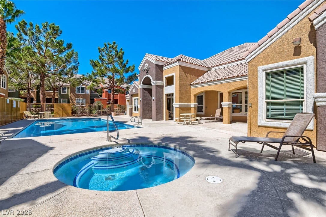 8101 W Flamingo Road, #1074, Las Vegas, NV 89147 An inviting swimming pool and circular spa sit alongside tiled-roof stucco buildings.