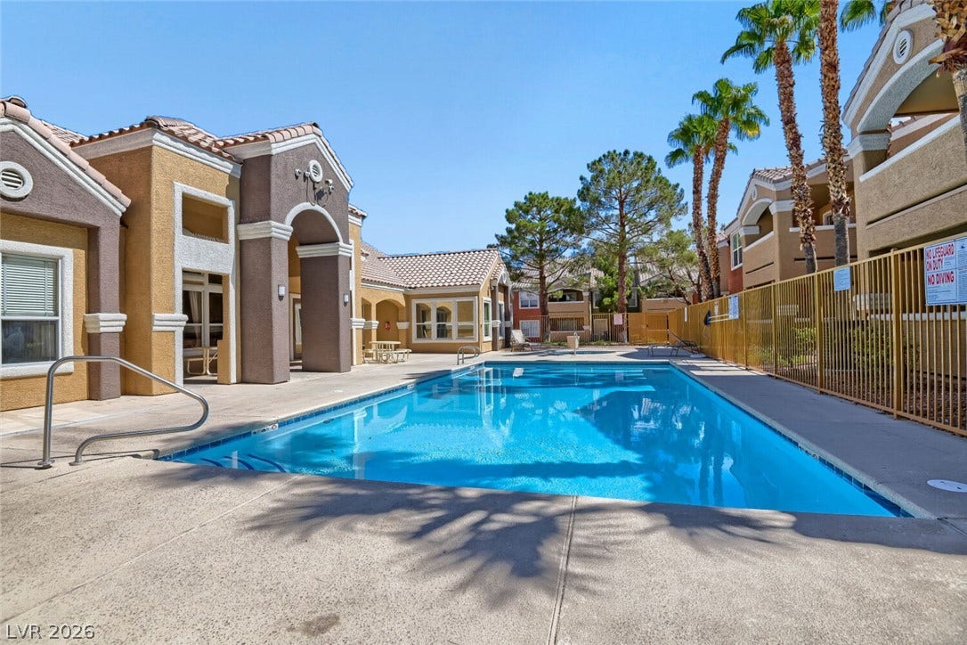 8101 W Flamingo Road, #1074, Las Vegas, NV 89147 Sun-drenched community pool area is surrounded by Spanish tile roofing and soaring palm trees.