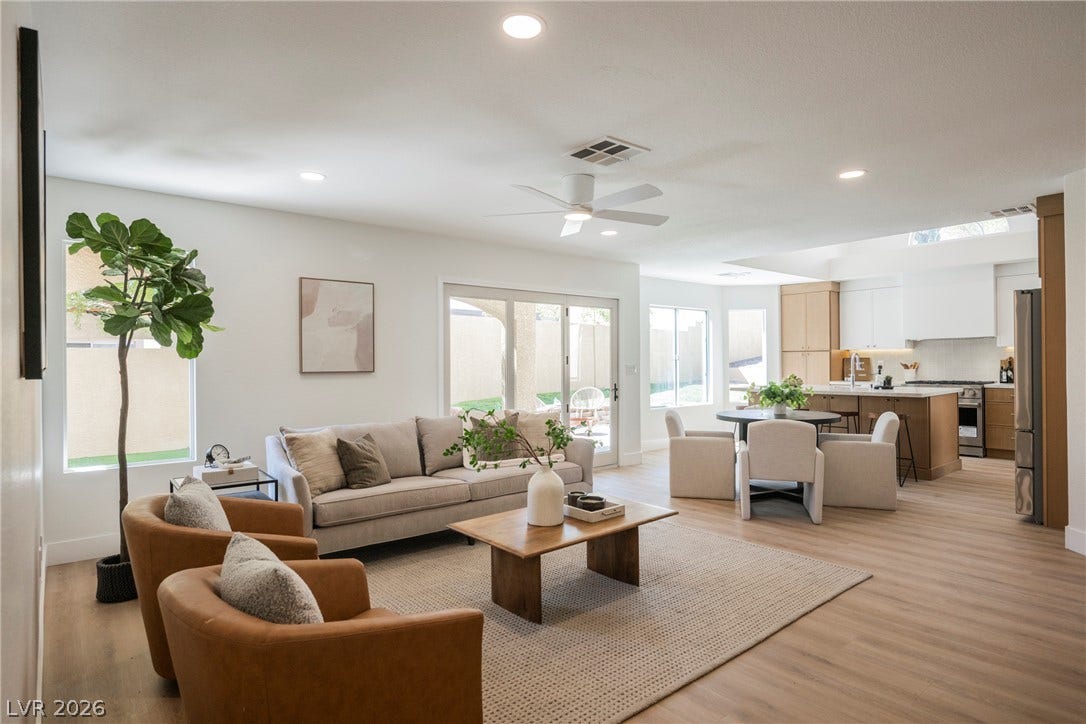 An open floor plan seamlessly connects the living area, dining space, and modern kitchen.