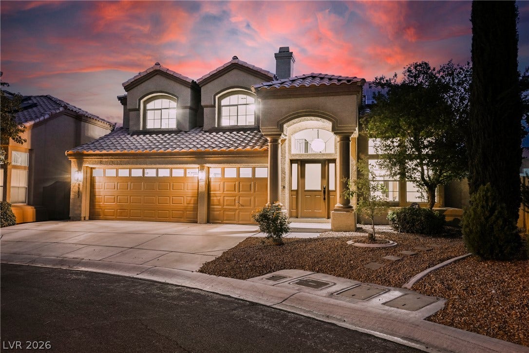 Stately stucco columns and barrel tile roofing define this impressive multi-level residence.