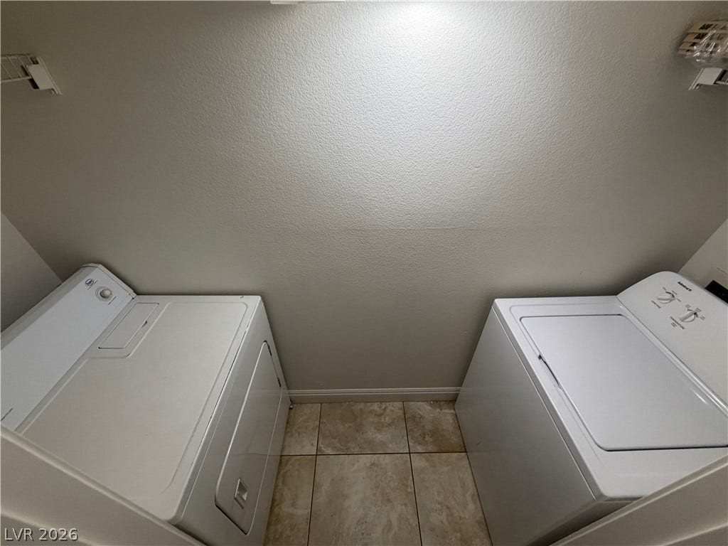 7255 W Sunset Road, #1167, Las Vegas, NV 89113 Tiled flooring and neutral walls frame this functional laundry space with overhead wire shelving.