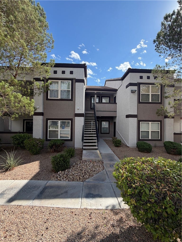 7255 W Sunset Road, #1167, Las Vegas, NV 89113 A paved concrete walkway leads to the entrance of this multi-level residential building.