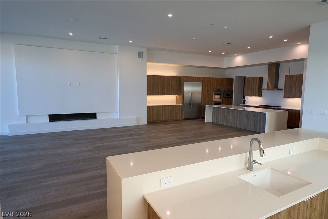 Smooth wood floors flow effortlessly through this expansive living space into the modern kitchen.