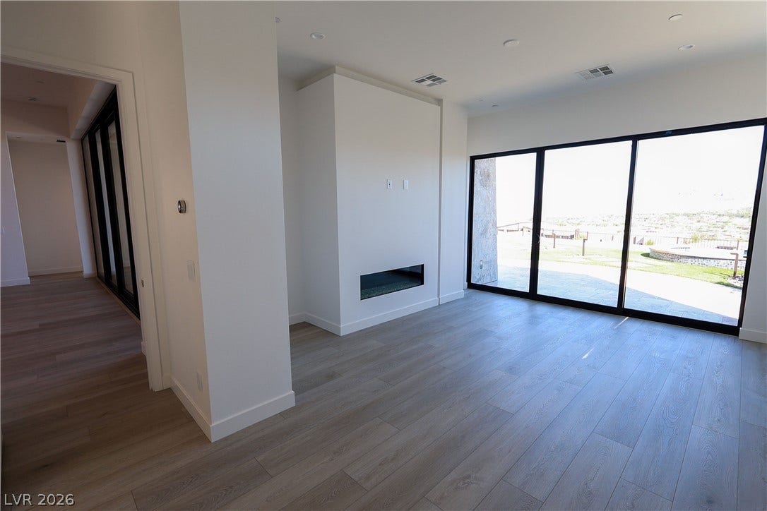 Gleaming wood floors and large sliding glass doors define this open living area.