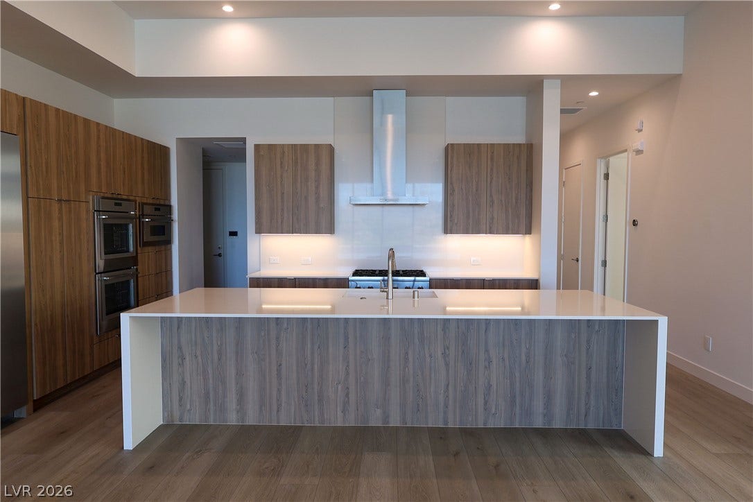 Sleek contemporary cabinetry and a massive waterfall island ground this modern open kitchen.