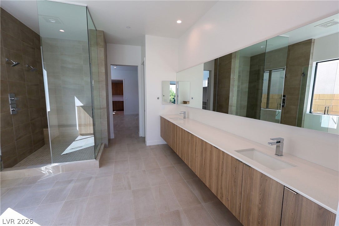 An expansive floating double vanity and a glass-enclosed walk-in shower define this modern bathroom.