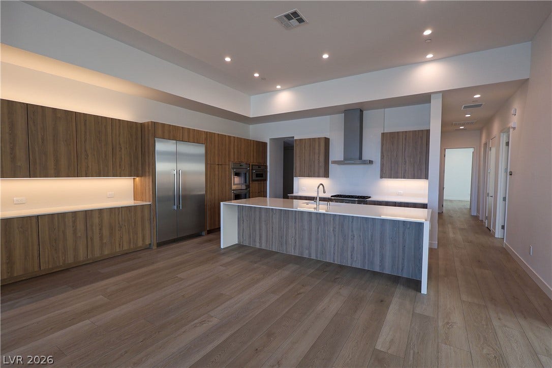 Sleek contemporary cabinetry and a massive central island define this open gourmet workspace.