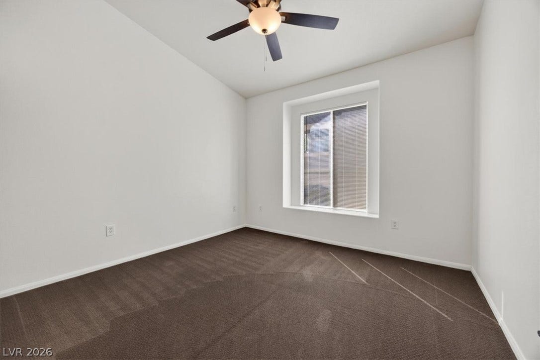 High ceilings and soft carpeting anchor this versatile bedroom space.