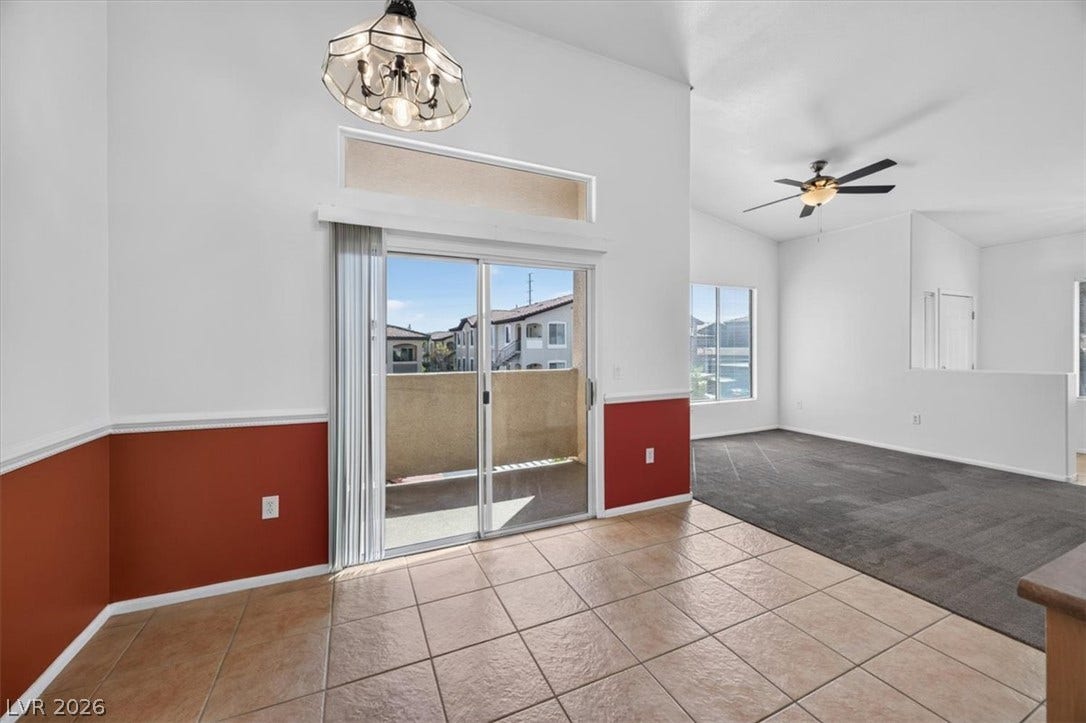 An open floor plan connects the tiled dining area to the carpeted living space.
