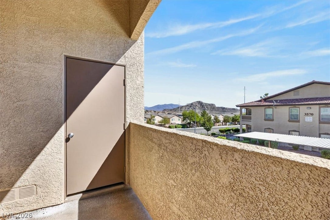 Step outside onto a private covered balcony showcasing scenic mountain and neighborhood vistas.