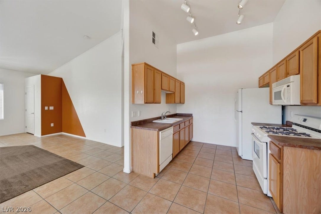 Tile flooring runs throughout this functional kitchen layout that opens directly to the living area.