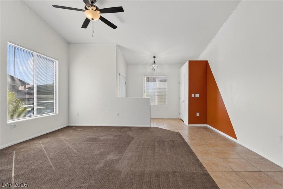 High ceilings and generous windows illuminate this open-concept layout with carpet and tile flooring.