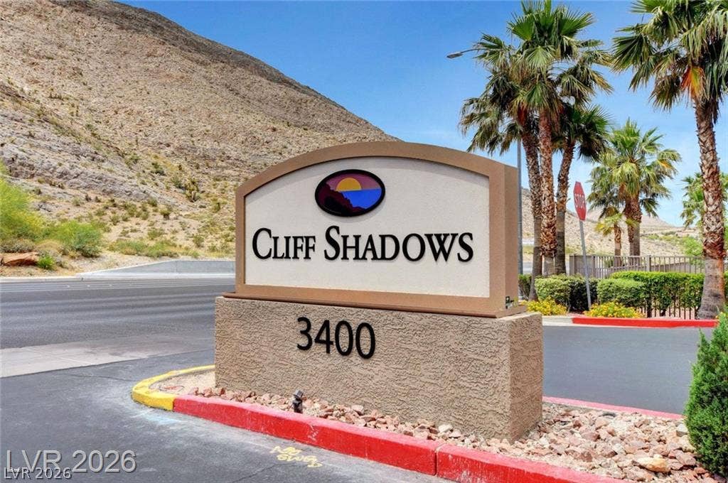 Welcoming community signage stands prominently against a dramatic desert mountain backdrop.