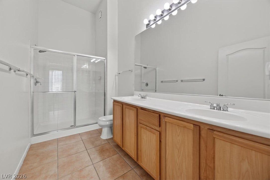 High ceilings and a dual-sink vanity elevate this bright bathroom.