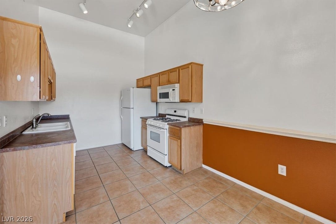 High ceilings and durable tile flooring highlight this functional kitchen space.
