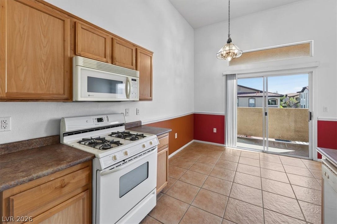 Sliding glass doors open from the tiled kitchen area to a private outdoor space.