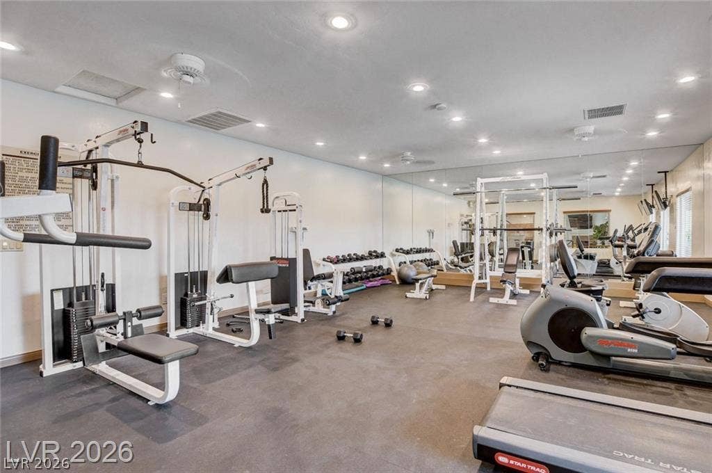 Recessed lighting and custom wall mirrors elevate this dedicated home exercise space.