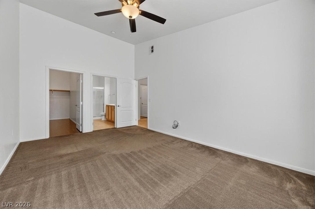 High ceilings and soft carpeting anchor this comfortable space with an attached bathroom.