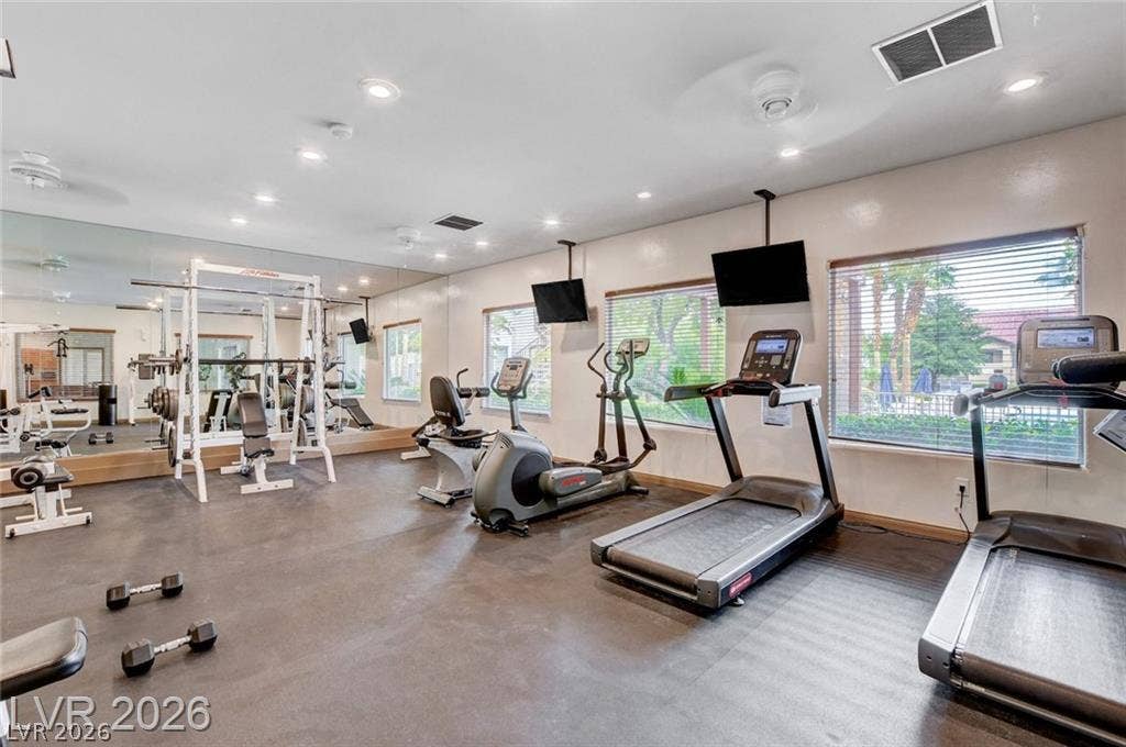 Large windows look out to the grounds from this well-equipped home fitness center.