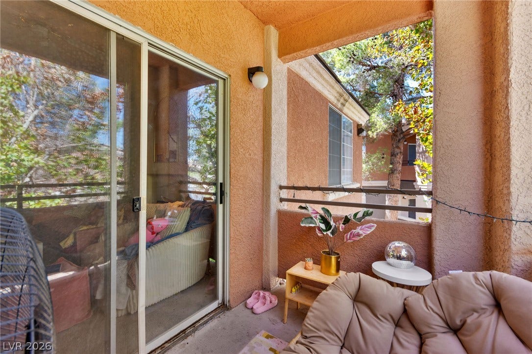 7628 Pacific Hills Avenue, #204, Las Vegas, NV 89128 A private covered balcony connects seamlessly to the interior through wide sliding glass doors.