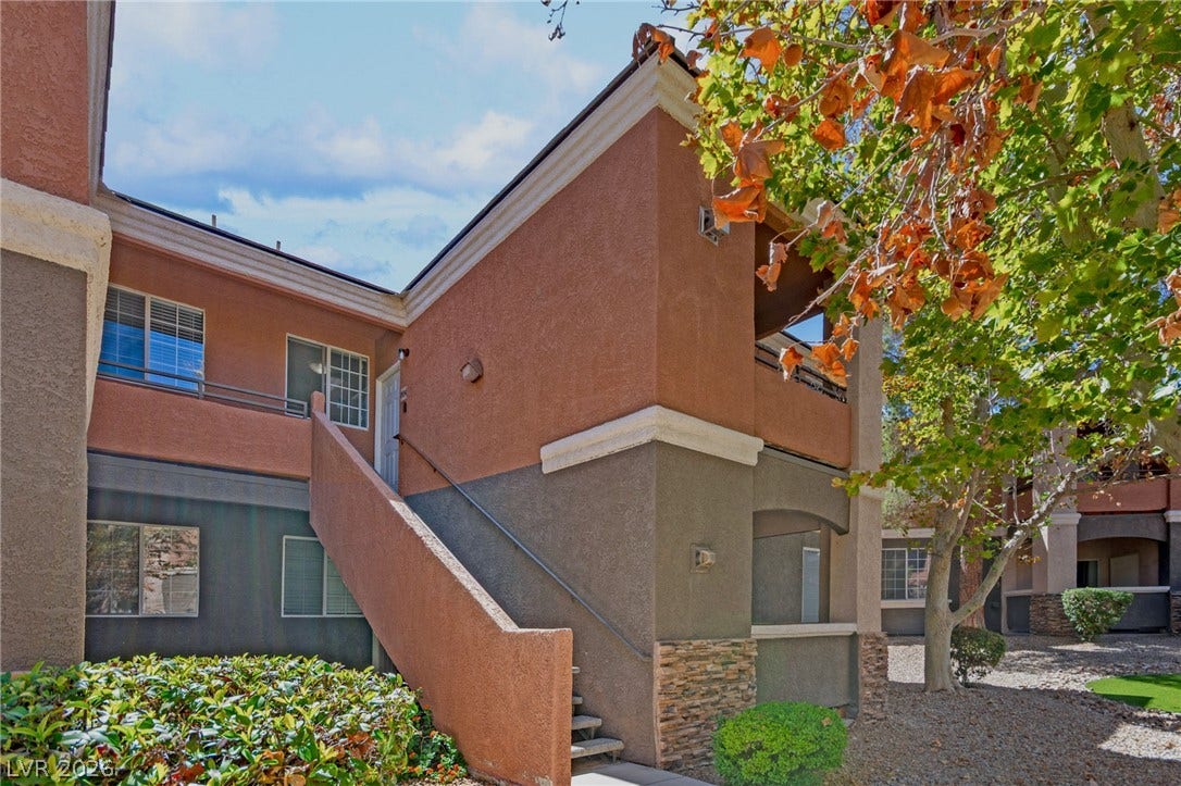 7628 Pacific Hills Avenue, #204, Las Vegas, NV 89128 Stucco exterior finishes and an open staircase define this modern multi-level residential facade.