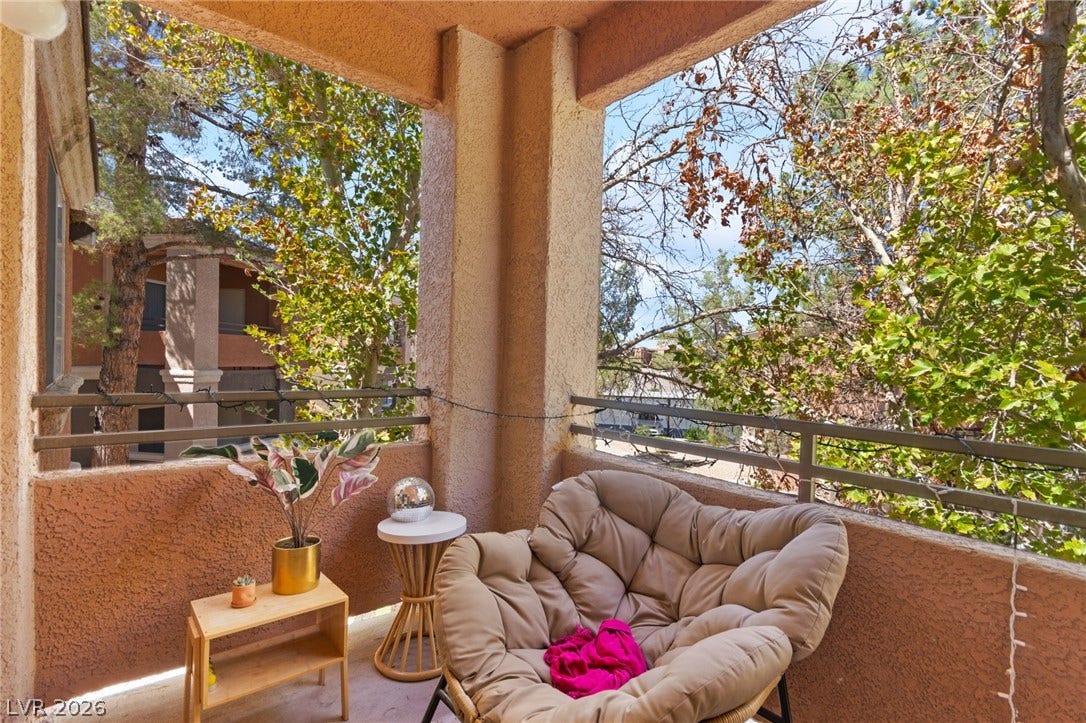 7628 Pacific Hills Avenue, #204, Las Vegas, NV 89128 A private covered balcony overlooks mature green trees.