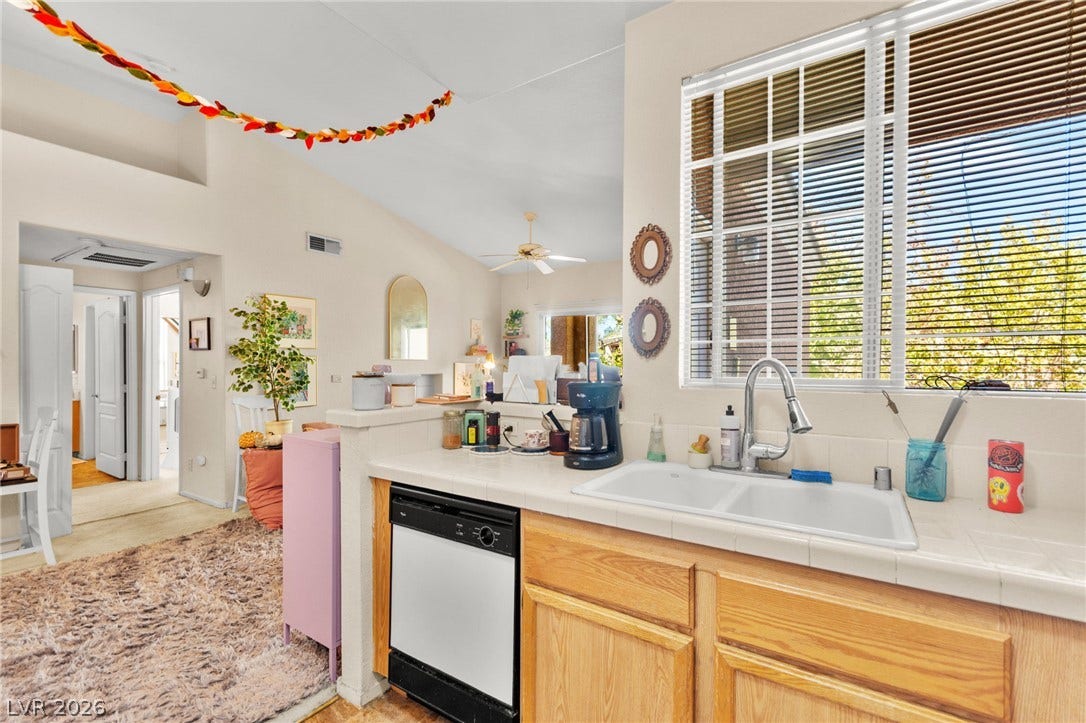 7628 Pacific Hills Avenue, #204, Las Vegas, NV 89128 An open floor plan connects the kitchen to the living area under vaulted ceilings.