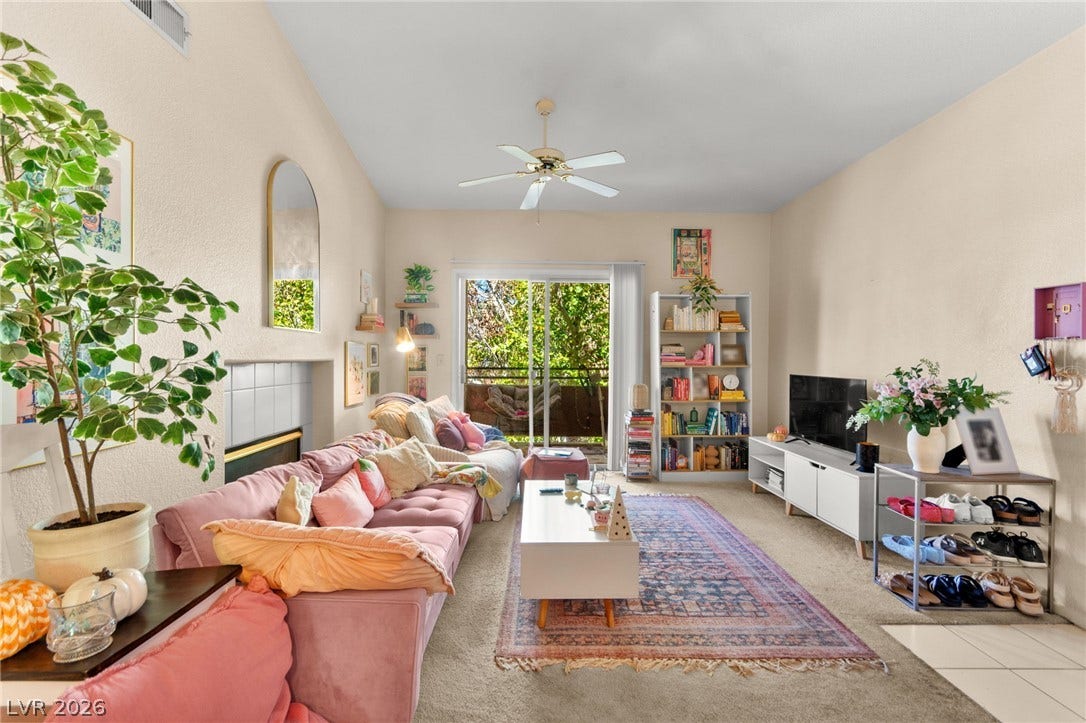7628 Pacific Hills Avenue, #204, Las Vegas, NV 89128 A spacious living room features soaring ceilings and sliding doors leading to a private balcony.