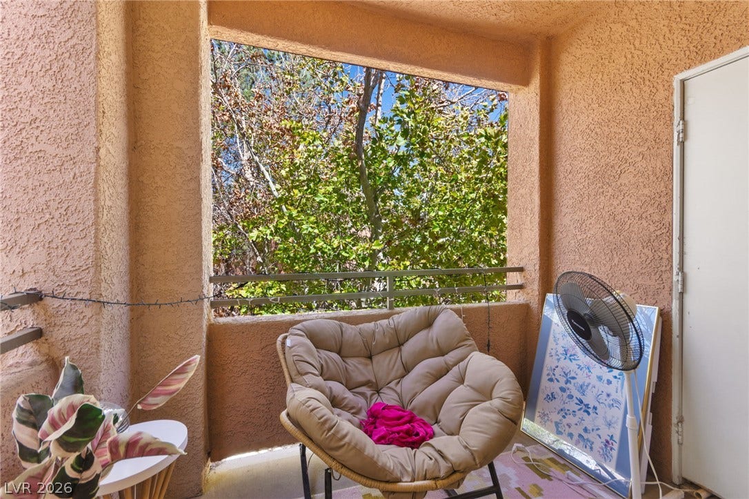 7628 Pacific Hills Avenue, #204, Las Vegas, NV 89128 An inviting covered balcony looks out onto lush, mature trees.