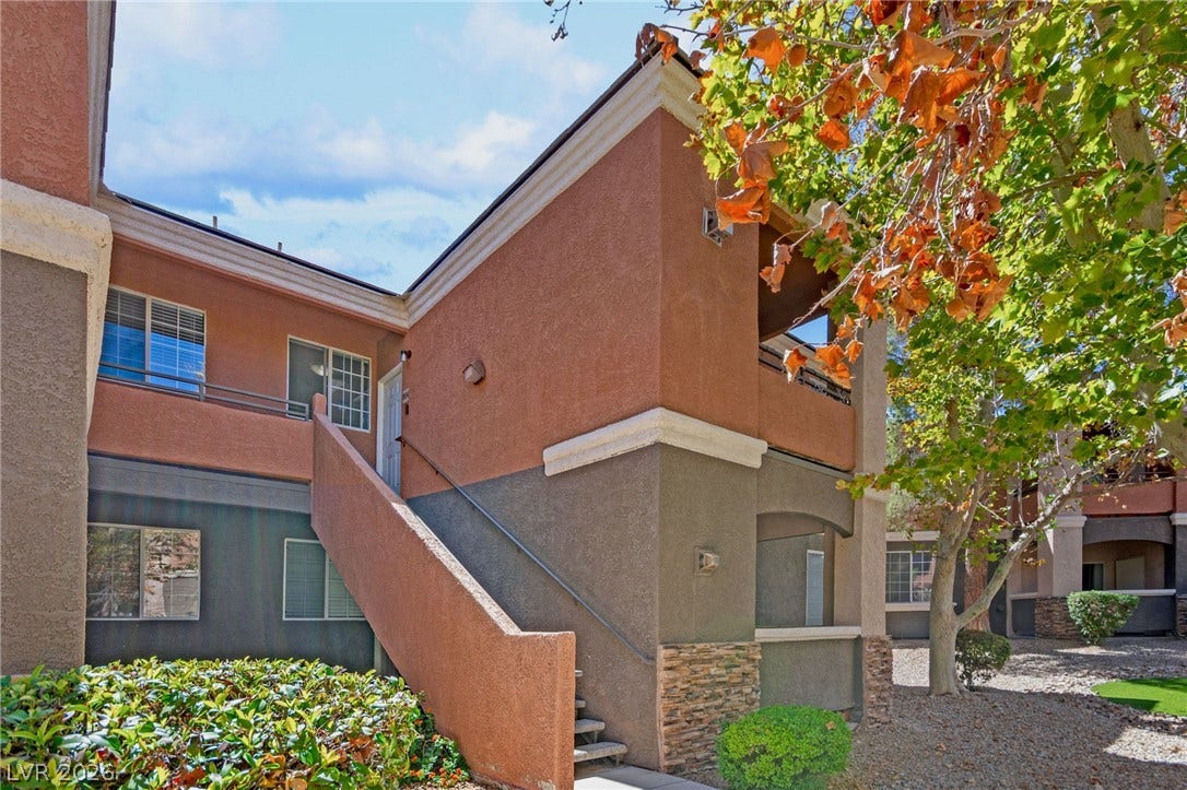 7628 Pacific Hills Avenue, #204, Las Vegas, NV 89128 An exterior staircase leads to the entrance of this multi-level stucco residence.