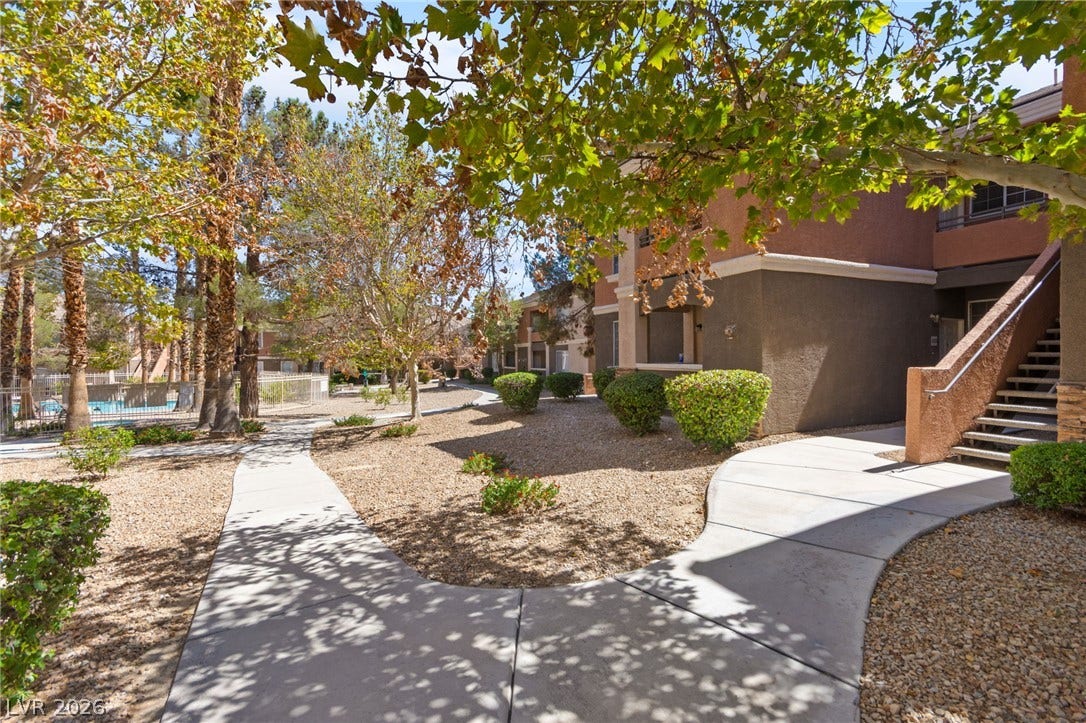 7628 Pacific Hills Avenue, #204, Las Vegas, NV 89128 Winding concrete pathways meander through landscaped grounds shaded by mature trees.