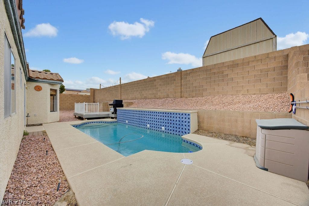 409 Groft Way, Henderson, NV 89015 An inviting backyard pool is bordered by concrete decking and secured by high privacy walls.
