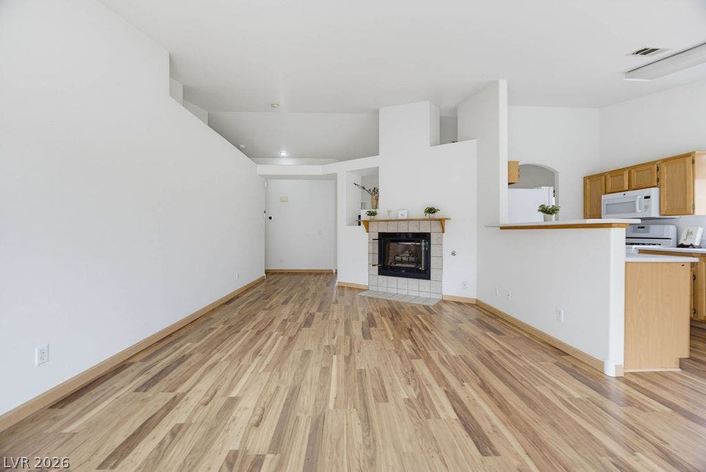 409 Groft Way, Henderson, NV 89015 Warm laminate flooring flows through this airy, open-concept living area centered on a fireplace.