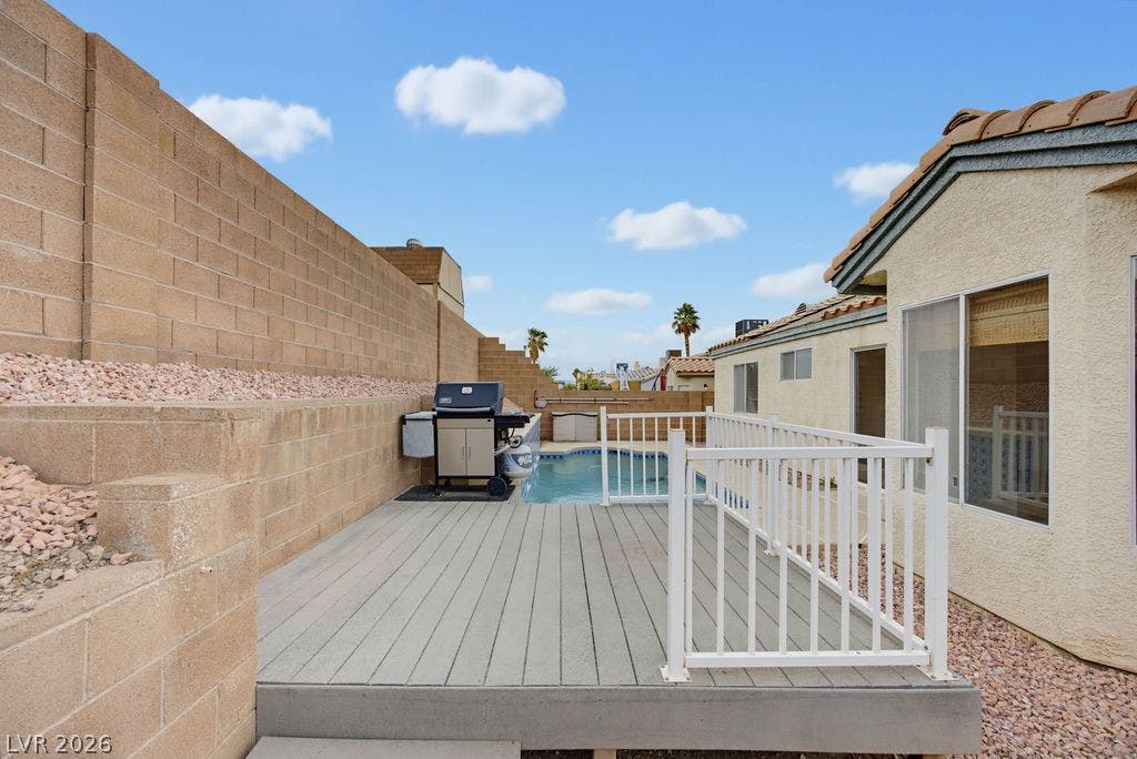 409 Groft Way, Henderson, NV 89015 An elevated wood deck overlooks a private swimming pool set against low-maintenance stucco exteriors.