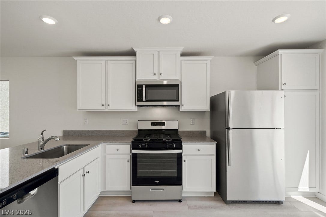 6724 Violet Cascade Avenue, Las Vegas, NV 89156 Gleaming stone countertops and stainless steel appliances anchor this modern cooking space.