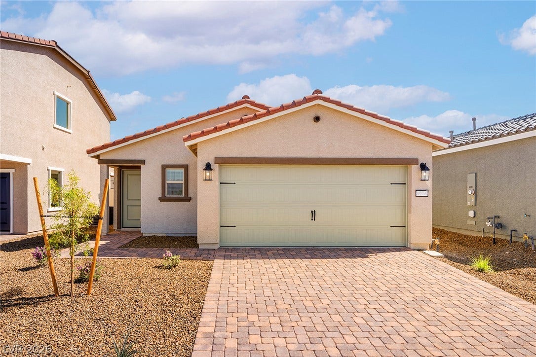 6724 Violet Cascade Avenue, Las Vegas, NV 89156 Spanish tile roofing and a paver driveway frame this single-story stucco home.