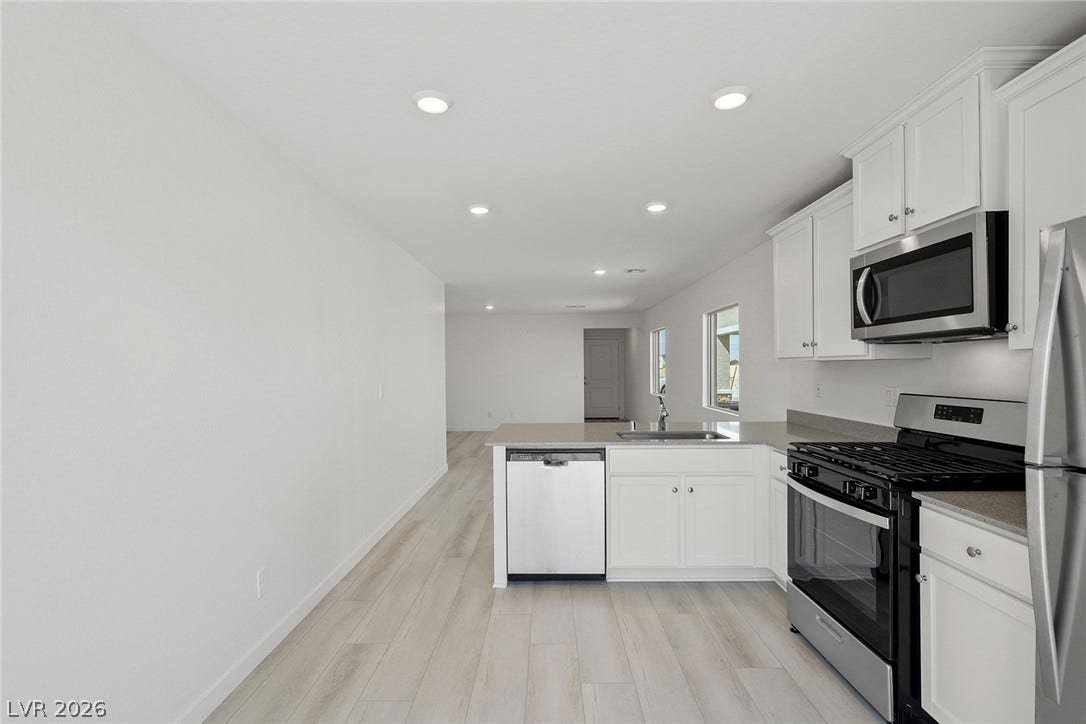 6724 Violet Cascade Avenue, Las Vegas, NV 89156 Clean lines and stone counters define this modern, open kitchen space with recessed lighting.