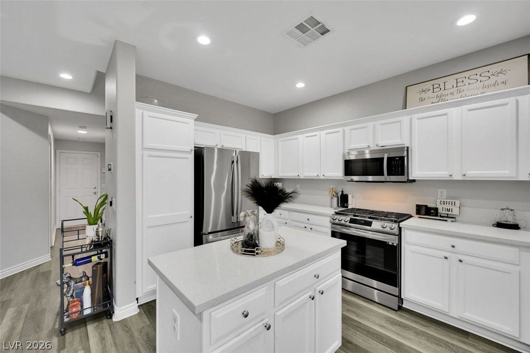 Gleaming stone countertops and stainless steel appliances anchor this modern cooking space.