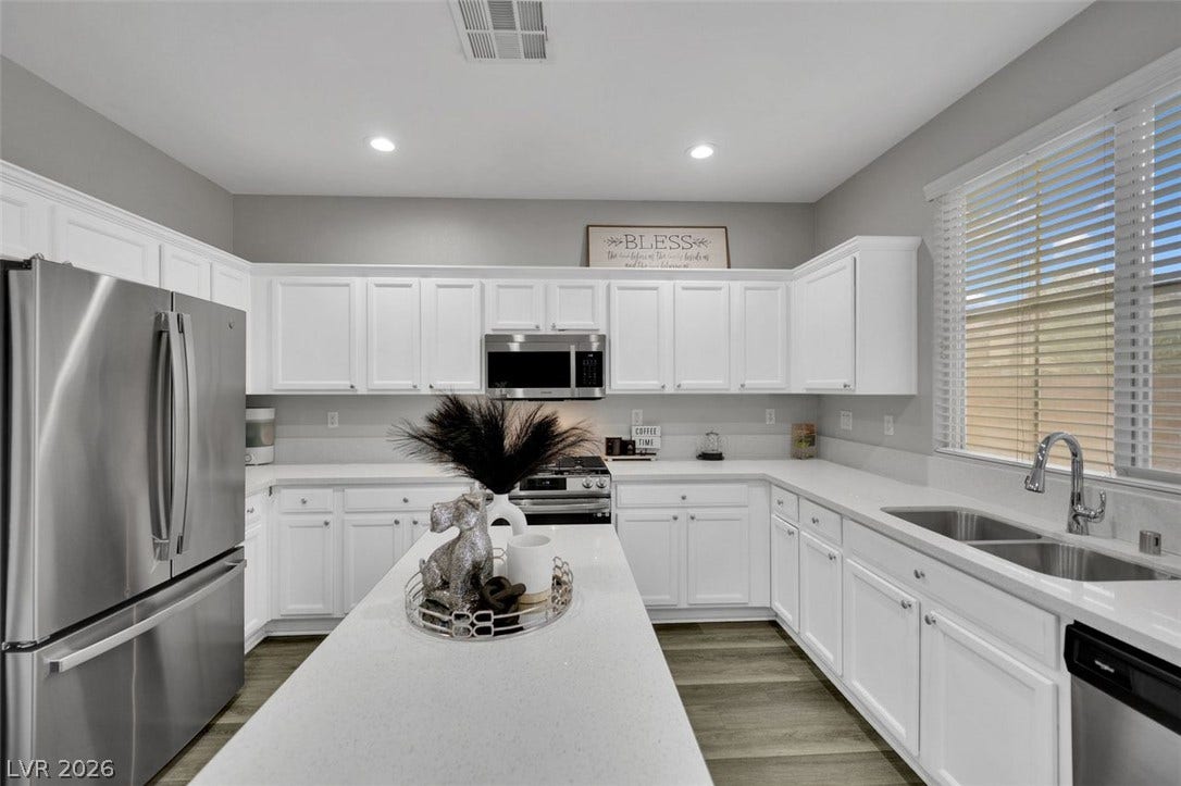 Crisp white cabinetry paired with durable countertops highlights this functional and bright kitchen design.