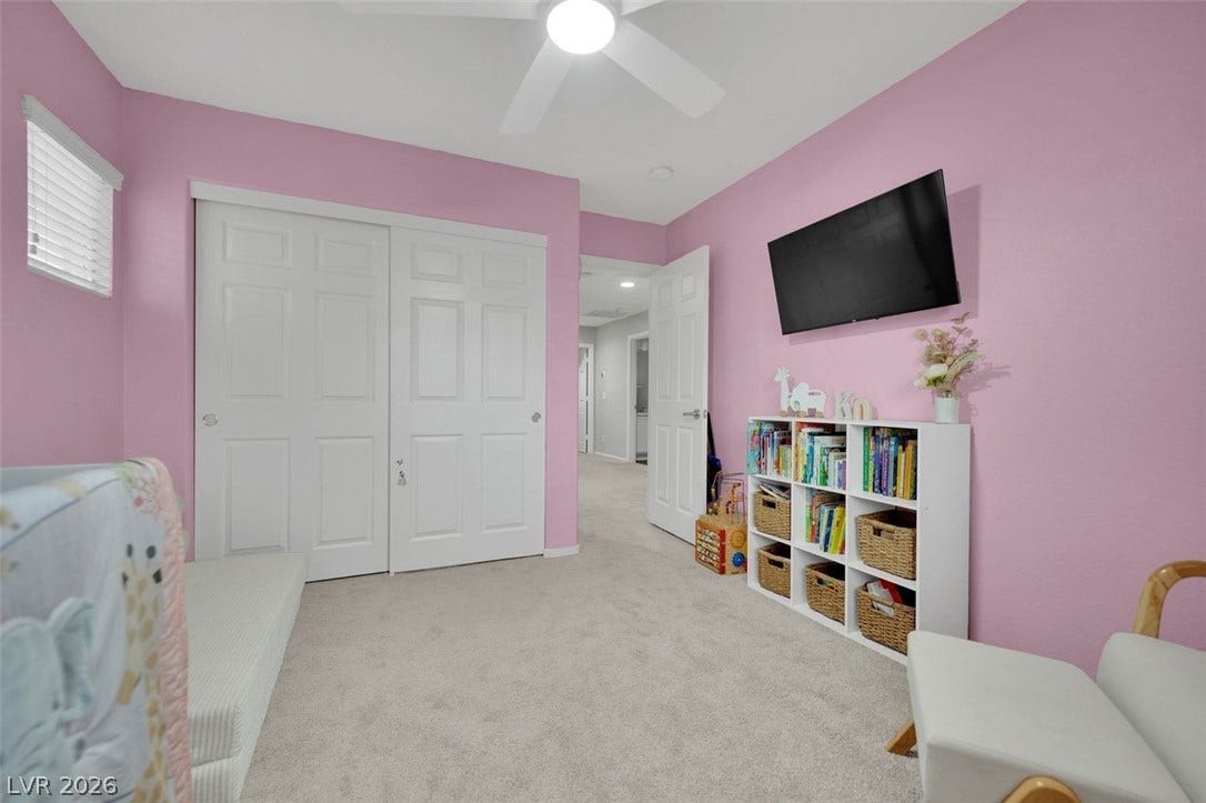 Plush carpeting and custom sliding doors define this charming secondary bedroom.