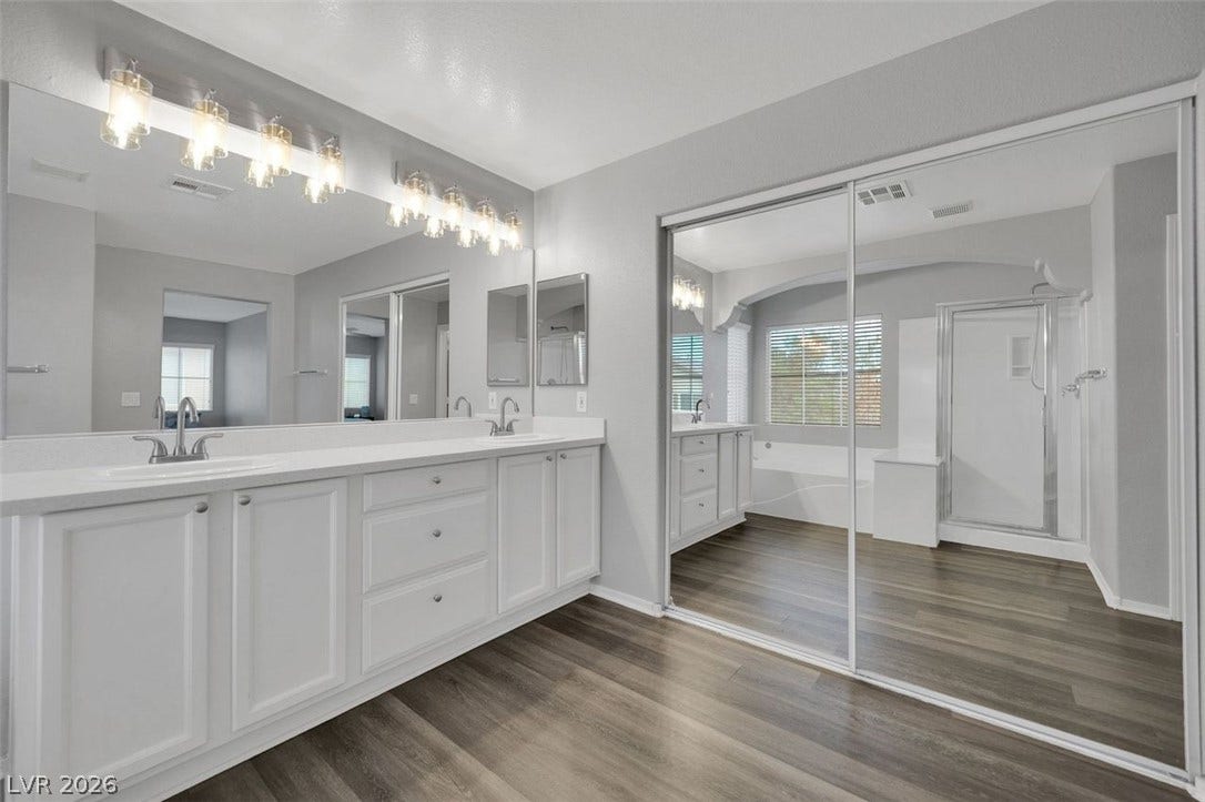 Clean lines and a spacious vanity highlight this modern bathroom space with wood-look flooring.